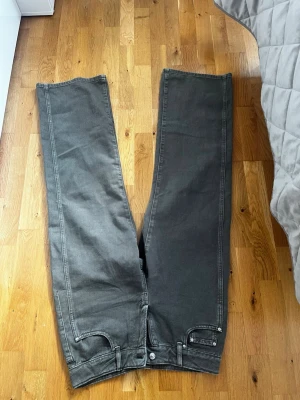 Grå raka jeans från Perfect Jeans - Säljer ett par grå jeans från Perfect Jeans i storlek 40. Jeansen har raka ben, klassisk femficksmodell och silverfärgade knappar. Materialet är mjukt och stretchigt för extra komfort. Perfekta till en avslappnad och trendig look.