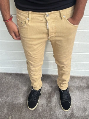 Dsquarred2 jeans - Hej! Säljer dessa dsquared2 jeans i beige färg! Modellen på bilden är 173cm och väger 74kg. Passformen är slim/straight och har storleken ”48” vilket motsvarar W32/L32. Tillverkade i Italien 🇮🇹. Som nya i skicket! 98% bomull 2% elastan. Hör av dig! 