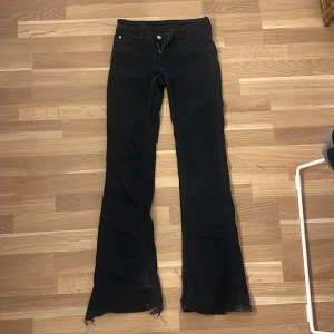 Svarta bootcut jeans från weekday - Säljer ett par svarta cheap monday bootcut jeans. De är slitna och fransiga nedtill. Jeansen har väldigt låg midja och utsvängda ben. Materialet är denim. 
