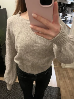 Beige, kortare stickad tröja med ballongärm - Beige stickad tröja, som är lite nopprig.