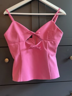 Rosa topp med rosetter - Supersöt rosa linnetopp från Zara med smala axelband och  rosetter framtill. Tröjan säljs tyvärr inte längre, använd fåtal gånger💕