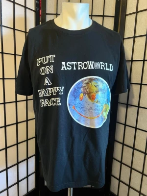 Travis Scott Astroworld Wish You Were Here Tee – Strl L - Travis Scott Astroworld “Wish You Were Here” T-shirt med “Put On A Happy Face”-tryck framtill och “Down To Earth”-tryck på ryggen.  Storlek: L  Skick: Mycket fint använt skick. Trycken är fortfarande klara och fina med normalt slitage från användning. Inga hål eller större fläckar. Se bilder för skick och detaljer.  📦 Skickas väl emballerad. 💬 Skicka gärna ett meddelande om du har frågor eller vill se fler bilder.