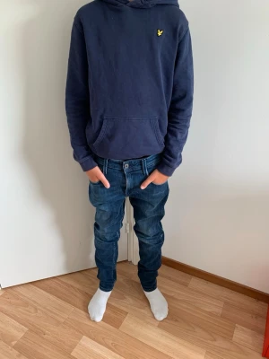 Replay Jeans - Säljer ett par mörkblå slim fit jeans med klassisk femficksdesign och snygga kontrastsömmar. Storlek W28/L30. Jeansen har normal midja och smal passform hela vägen ner. Perfekta till vardags för en avslappnad men ändå stilren look.