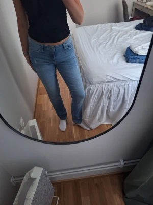 Ljusblå raka low waist jeans - Säljer ett par ljusblå jeans med rak passform och klassisk femficksdesign. Jeansen har låg midja och stängs med dragkedja och knapp. Perfekta till en avslappnad stil och passar till det mesta i garderoben.