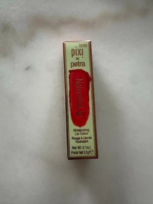 Pixi by Petra NaturelleLip Poppy - Säljer ett NaturelleLip läppstift från Pixi by Petra i färgen Poppy. Läppstiftet är återfuktande och har en intensiv röd nyans. Oöppnad förpackning.