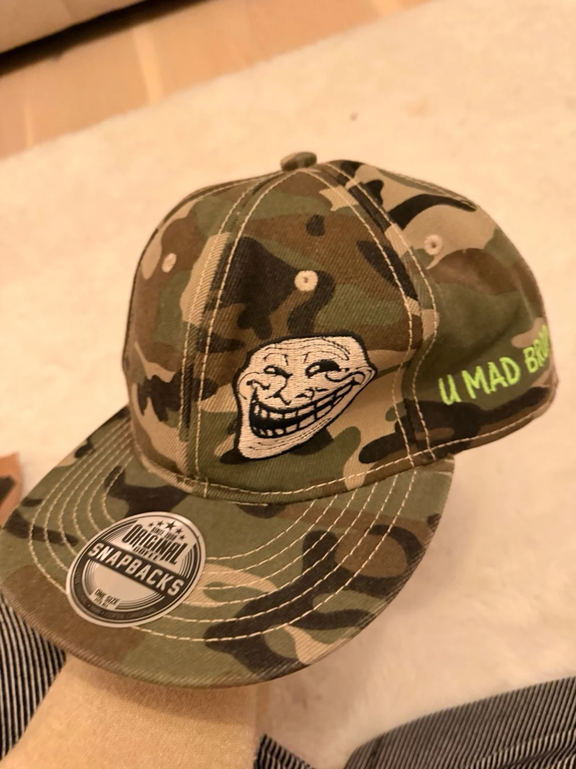 Camouflage keps med trollface och text