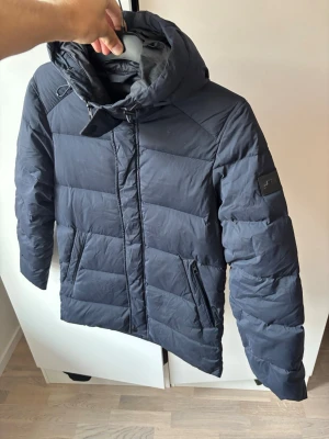 Grym j.lindeberg dunjacka XS - Jättefin blå dunjacka perfekt nu till vintern av högsta kvalité från j.lindeberg och storlek XS. Grym passform i använt men mycket bra skick!