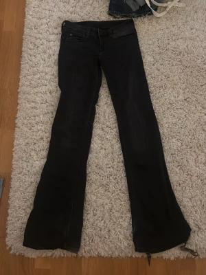 Weekday Svarta bootcut jeans - 29/34. Snygga svarta bootcut jeans med klassisk femficksmodell och hällor för skärp. Jeansen har en lätt utsvängd passform nedtill och är tillverkade i ett stretchigt denimtyg för extra komfort.