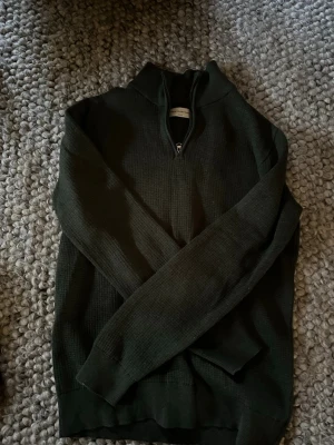 These Glory Days stickad half zip - Mörkgrön half zip tröja från Volts egna märke. Tröjan är i 100% ekologisk bomull och väldigt gott skick