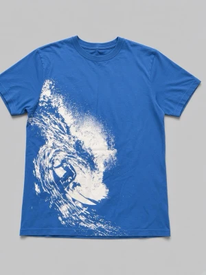 Blå t-shirt med surftryck - Snygg blå t-shirt med ett stort vitt tryck av en surfare i vågor på framsidan. T-shirten har rund hals och korta ärmar. Perfekt för dig som gillar strandvibbar och coola motiv. Tillverkad i mjuk bomull.