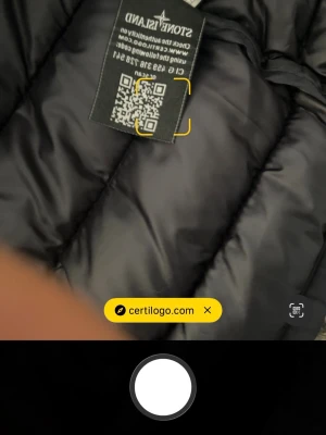Mörkblå dunjacka  - Snygg mörkblå dunjacka  med huva och klassisk patch på ärmen. Jackan har quiltad design och dragkedja framtill. Perfekt för kalla vinterdagar och riktigt stilren look.