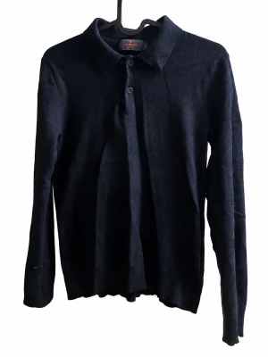 Morris Stockholm 100% Merinoull Polo – Marinblå XS - Mörkblå långärmad piké/polotröja från Morris Stockholm i 100% merinoull. Klassisk krage med knappar framtill och väldigt stilren modell. Storlek XS. Mjuk och exklusiv merinoull som passar perfekt både casual och mer dressat. Fint begagnat skick. 