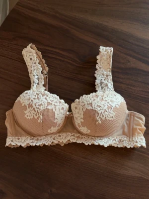 Intimissimi bh Pretty Flowers - Säljer en beige bh med vadderade kupor men ingen push up. Vacker vit spets över kuporna och axelbanden. Bh:n har en feminin design med spetskant nedtill och justerbara axelband. Har sålts på Intimissimi för över 550 kr, knappt använd 🩷