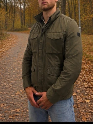 BOSS Orange militärjacka/field jacket – storlek 50/L - BOSS Orange militärjacka/field jacket – storlek 50/L  Olivgrön jacka från BOSS Orange med hög krage, dragkedja och fyra praktiska framfickor. Klassisk militärinspirerad modell som passar perfekt som vår- och höstjacka.  Storlek 50, motsvarar ungefär L. Modellen på bilden är 186 cm. Fint begagnat skick.  Material: 58 % bomull och 42 % polyamid.  Uppskattat nypris cirka 3 500 kr.  Modellen är 186cm lång.   #boss #bossorange #hugoboss #hugobossjacket #fieldjacket #militärjacka #utilityjacket #herrj