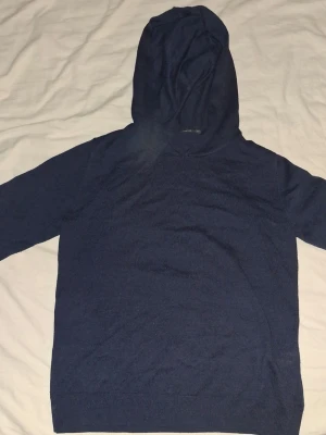 Mörkblå hoodie från LMTD - Mysig mörkblå hoodie från LMTD i storlek S. Tillverkad i mjukt stickat material med klassisk huva och långa ärmar. Perfekt för en chill och avslappnad stil. Enkel design utan tryck eller detaljer.