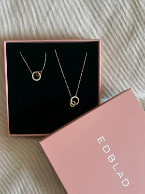 Guldhalsband och armband från Edblad  - Säljer detta superfina guldiga settet med halsband och armband från Edblad då jag fick många likadana i studentpresent. Båda två har plomberingen kvar och är helt oanvända! På hemsidan kostar armbandet 449kr och halsbandet 499kr men säljer settet för endast 650kr! 