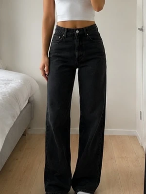 Svarta vida jeans med hög midja W28 L32 - Säljer ett par svarta jeans med hög midja och breda ben. Jeansen har klassisk femficksdesign och raka sömmar. Perfekta för dig som gillar en avslappnad och trendig stil. Materialet är denim i bomull. NY med prislapp