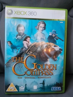 The Golden Compass Xbox 360 spel - The Golden Compass är ett actionäventyrsspel till Xbox 360 baserat på filmen med samma namn. Omslaget är blått med filmkaraktärer och en bepansrad isbjörn. Spelet kommer i ett klassiskt plastfodral och är utvecklat av SEGA.