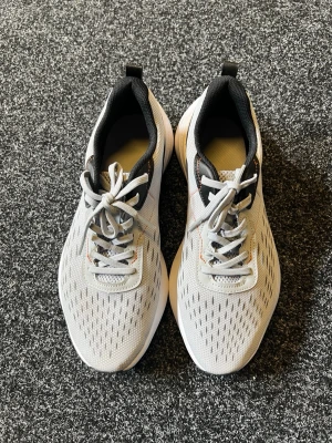 Kalenji joggningsskor - Använda fåtal gånger.                                              Säljer dem eftersom att dem blivit små.      Snygga sneakers i grå mesh med svarta och vita detaljer samt vita snören. Skorna har en sportig look med ventilerande ovandel och bekväm sula. Perfekta för dig som gillar stilrena och lätta sneakers med modern design.