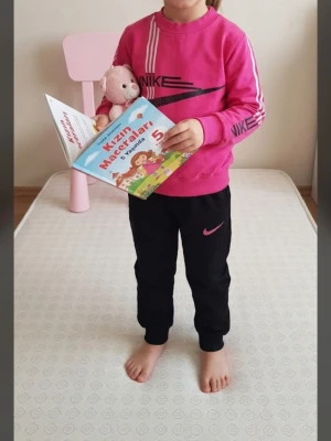 Barn överoll Storlek  -110 - Snygg rosa sweatshirt från Nike med svart logga och vita ränder på ärmarna. Tröjan har rund hals, ribbade muddar och är långärmad. Perfekt för en sportig och avslappnad stil. Storlek -110