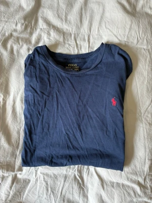 Ralph Lauren Tröja  - Säljer min fina ralph lauren tröja med ett enkelt tryck. Det klassiska märket med hästen. Väldigt fin i färgen mörkblå och passar till de flesta kläderna. Ger verkligen ett upplyft i stilen och passar dig som gillar kända varumärken. Det finns ett litet hål i tröjan. Hör av er vid funderingar, vi hörs!