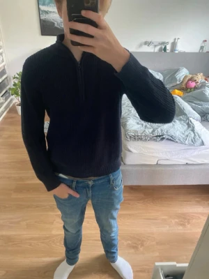 Mörkblå stickad tröja M(barnstorlek) - Mörkblå stickad tröja från grunt med halv dragkedja i halsen och ribbade muddar. Nypris 600-850kr