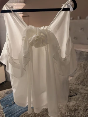 Vit halterneck topp - Snygg vit halterneck blus i tunn, luftig chiffong med volangdetaljer och stor rosett framtill, oanvänd 