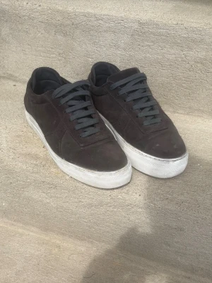 Mörkblå arigato skor i mocka - Snygga mörkblå sneakers i mocka med matchande mörka skosnören och vit, tjock sula. Klassisk låg modell som passar till det mesta och ger en clean look. Perfekta för dig som gillar stilrena och enkla skor. Passar 41-42