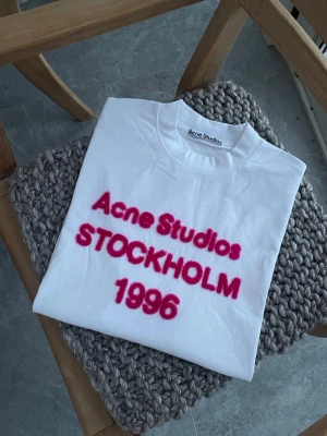 Acne Studios T-Shirt - Supersnygg Acne t-shirt till tjej med rosa fluffig text. Storlek S. Passformen är oversized/baggy. Alltså en avslappnad luftig passform, passar därför också större storlek. Perfekt att matcha till trendiga outfits. Skickar snabbt!🤍✨