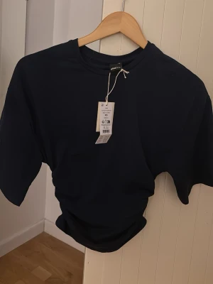 Mörkblå basic t-shirt - En enkel och stilren mörkblå t-shirt med rund hals och korta ärmar. Perfekt till jeans eller shorts för en clean look. Tillverkad i mjuk bomull som känns skön mot huden.