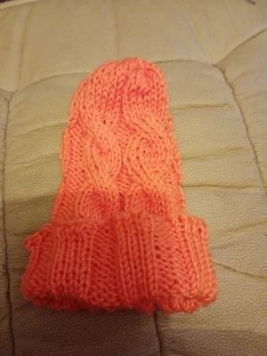 Baby Stickad orange mössa med flätmönster - Säljerbaby  en stickad mössa i en snygg orange färg. Mössan har ett klassiskt flätmönster och en bred uppvikt kant. Perfekt för dig som vill ha en varm och trendig accessoar till hösten eller vintern. Materialet känns mjukt och bekvämt. Mjuk och töjbar.
