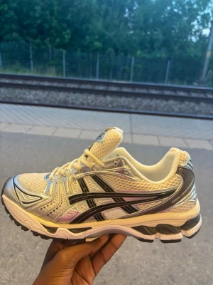 Gula och silvriga Asics sneakers - Pris kan diskuteras  Ny köpte fast passade inte mig darför säljer jag de här Snygga sneakers från Asics i gult och silver med svarta detaljer. Skorna har mesh-ovandel för bra ventilation, reflekterande partier och GEL-dämpning i sulan. Klassisk låg modell med sportig vibe och robust yttersula för bra grepp.