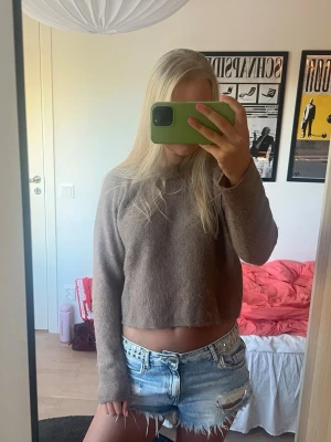 Ljusbrun stickad tröja - Mysig ljusbrun stickad tröja med rund halsringning i en lite kortare modell🤎 Innehåller bland annat ull och alpacka. Tröjan har en enkel och stilren design med ribbstickade muddar vid halsen. 