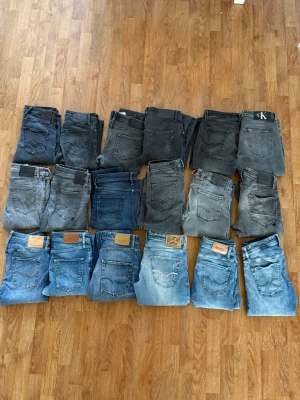 Mix av blå och grå jeans - Säljer ett gäng jeans i olika blå och grå nyanser. Modellerna varierar mellan slim och regular fit, vissa med klassiska läderpatchar på bakfickan. Några jeans har tydliga märken som Replay och Calvin Klein. Perfekt för dig som vill ha flera stilar att välja mellan.