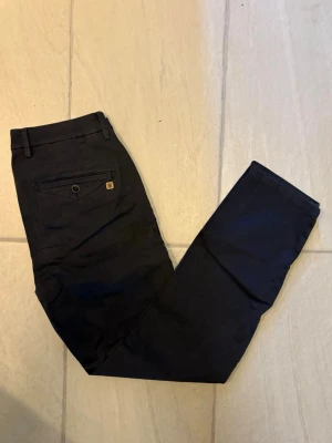 Hansen & Jacob chinos marinblå herr  - Snygga mörkblå chinos i storlek W33 L32 med klassisk passform och en bakficka med knapp och liten metallogo. Från märket Hansen & Jacob med ett nypris på 2000kr. Skriv gärna vid fler funderingar:)