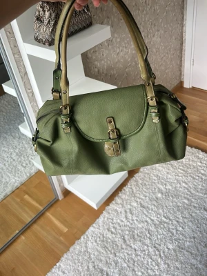 Handväska  - Olivgrön handväska, köpt på Plick. Den har en del fläckar på insidan 💚