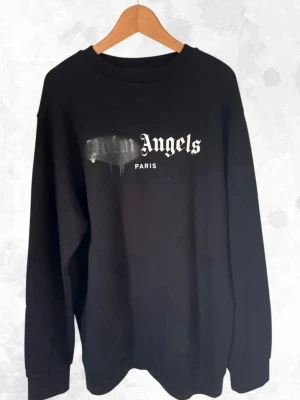 Palm Angels sweatshirt - Säljer denna Palm Angels sprayed logo crewnecken i svart färg. den är aldrig använd med  tags som fortfarande hänger kvar. tröjan är från 2021 och går alltså inte att hitta ny längre. Den är i storlek L men sitter mer oversize. svarar gärna på frågor om det skulle vara något.