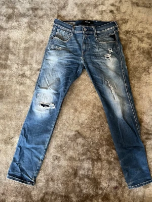 Blå Replay Annabass Jeans - Säljer ett par blå jeans från Replay med slitningar. Jeansen har fem fickor, normal midja. Perfekta för dig som gillar en trendig och avslappnad passform. Sitter riktigt nice på och skulle helst vilja ha kvar dem om de passade. Storlek, midja 30 längd 30. Om du har frågar är det bara att fråga på. Pris går att diskutera med seriösa köpare. Kolla in min profil och se om du hittar något mer intressant. Mvh Larsen_Closet
