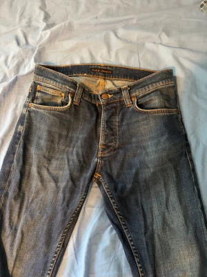 Grim Tim Indigo Myth W30 L32 - Säljer ett par klassiska blå jeans från Nudie Jeans.