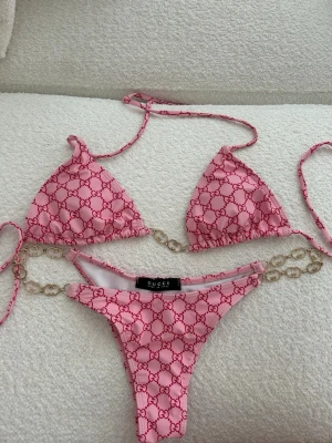 Rosa Bikini med gulddetaljer - ✨Rosa bikini med gulddetaljer i Gucci-inspirerad design. Använd ett fåtal gånger och i mycket fint skick. Bekväm passform och snygg färg till sommaren.