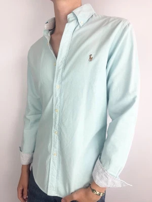 Ralph Lauren skjorta turkos slimfit - Ralph Lauren Skjorta Märke: Polo Ralph Lauren Storlek: M Passform: Slimfit Färg: Turkos Skick: Mycket bra Beskrivning: några mindre fläckar, går möjligtvis bort i tvätt. Modellen på bilden: 183 cm / 72 kg