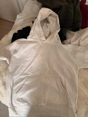 Vit hoodie från VAIYA med huva - Säljer en enkel och stilren vit hoodie från VAIYA i storlek 170. Hoodien har en klassisk huva och ribbade muddar vid ärmsluten. Perfekt för dig som gillar en clean och avslappnad look. Materialet känns mjukt och bekvämt mot huden.