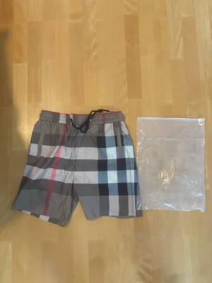 Rutiga badbyxor från Burberry - Säljer ett par snygga Burberry shorts helt nya och aldrig använda perfekt för sommaren Stl L pris går att diskutera 