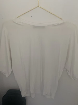 Vit oversized t-shirt med lös passform - En enkel och stilren vit t-shirt med oversized och lös passform. T-shirten har korta ärmar och är tillverkad i ett mjukt material som känns skönt mot huden. Perfekt för en avslappnad look och lätt att matcha med allt.
