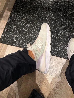 Beige New Balance sneakers - Säljer ett par snygga beigea New Balance sneakers med mesh- och mockadetaljer. Skorna har vita och ljuslila inslag samt en chunky vit sula. Klassisk New Balance-logga på sidan och låga snörningar för en clean look. Ett hål men syns knappt och man kan fixa detta själv 