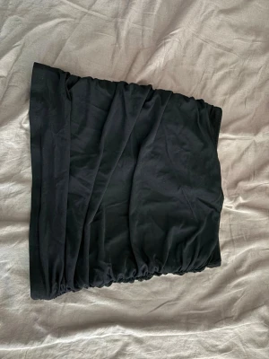 Svart kortkjol från SHEIN - Svart kortkjol från SHEIN i stretchigt material med enkel design. Kjolen har resår i midjan och är tillverkad i en mjuk polyamidblandning som ger en bekväm passform. Perfekt att matcha med en crop top eller oversized hoodie.