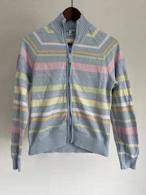 Lacoste Stickad cardigan/ziptröja - Lacoste Stickad cardigan/ziptröja  Storlek: 42  Passform: Regular fit Krage: Hög ribbstickad ståkrage (Mock Neck) Material: 100% Bomull Skick: Tröjan är i ett väldigt fint skick utan defekter  Nypris cirka: 1 600 kr