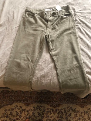 Ljusgröna raka jeans - Snygga ljusgröna jeans med rak passform och klassisk femficksdesign. Jeansen har normal midja och är tillverkade i ett denimtyg som känns slitstarkt. Perfekta för dig som vill ha en unik färg på dina jeans.