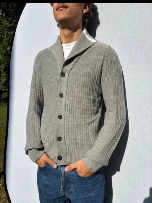 J.Lindeberg cardigan S -  Hej och välkommen till byTorén. Detta är en kofta från J.Lindeberg i storlek S med normal passform. Modell på bild är ca 182, 67kg. Plagget är i bra skick utan några defekter. Tveka inte på att höra av dig, även om det skulle vara minsta lilla;) 