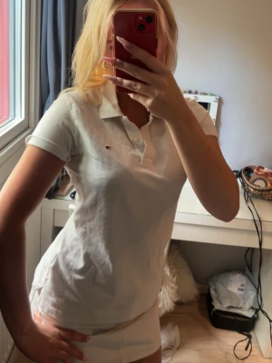 Vit Tommy Hilfiger pikétopp  - Säljer en vit pikétopp från Tommy Hilfiger , har en liten gul fläck som knappt syns men går säkert bort i tvätten (därför jag satt acceptabelt skick)